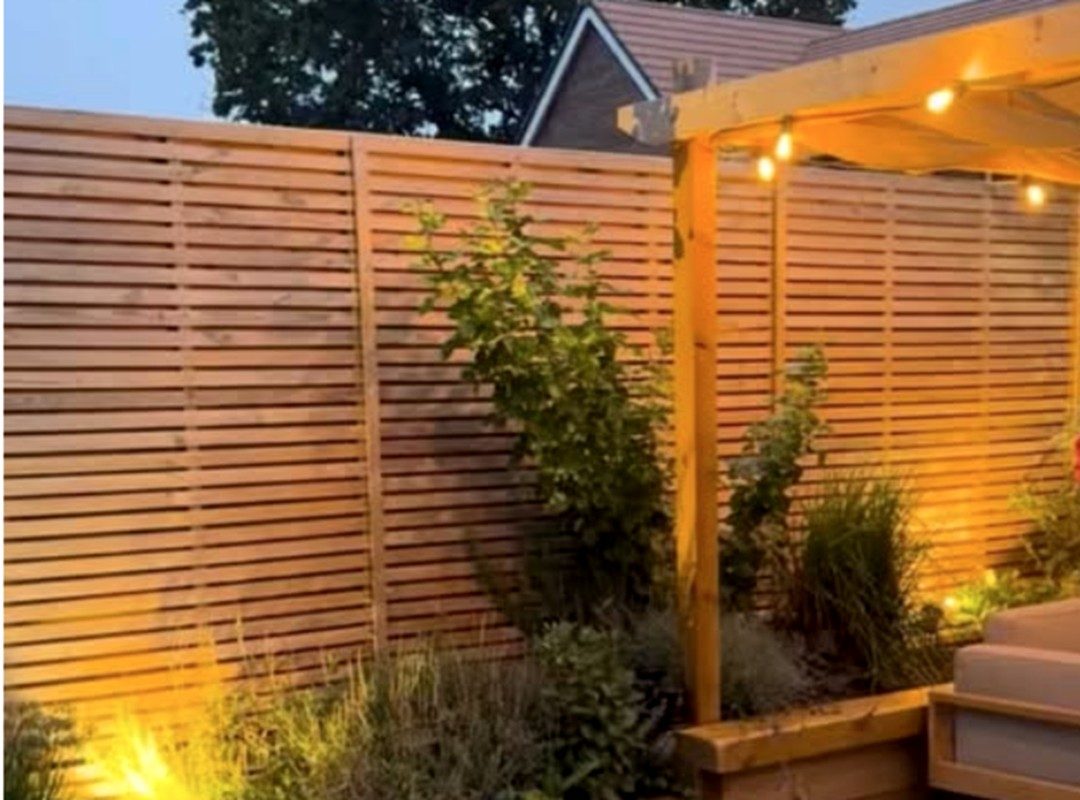 Garden fence and planting lit from below
