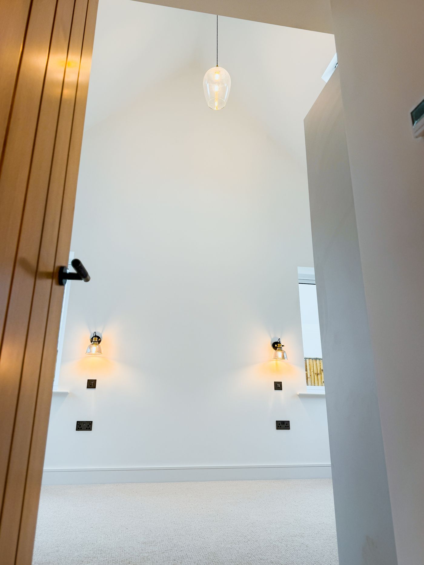 Vaulted bedroom with pendant and wall lights