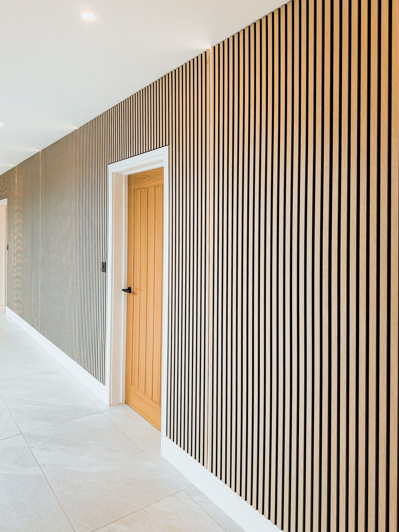 Hallway with timber slat wall and downlights
