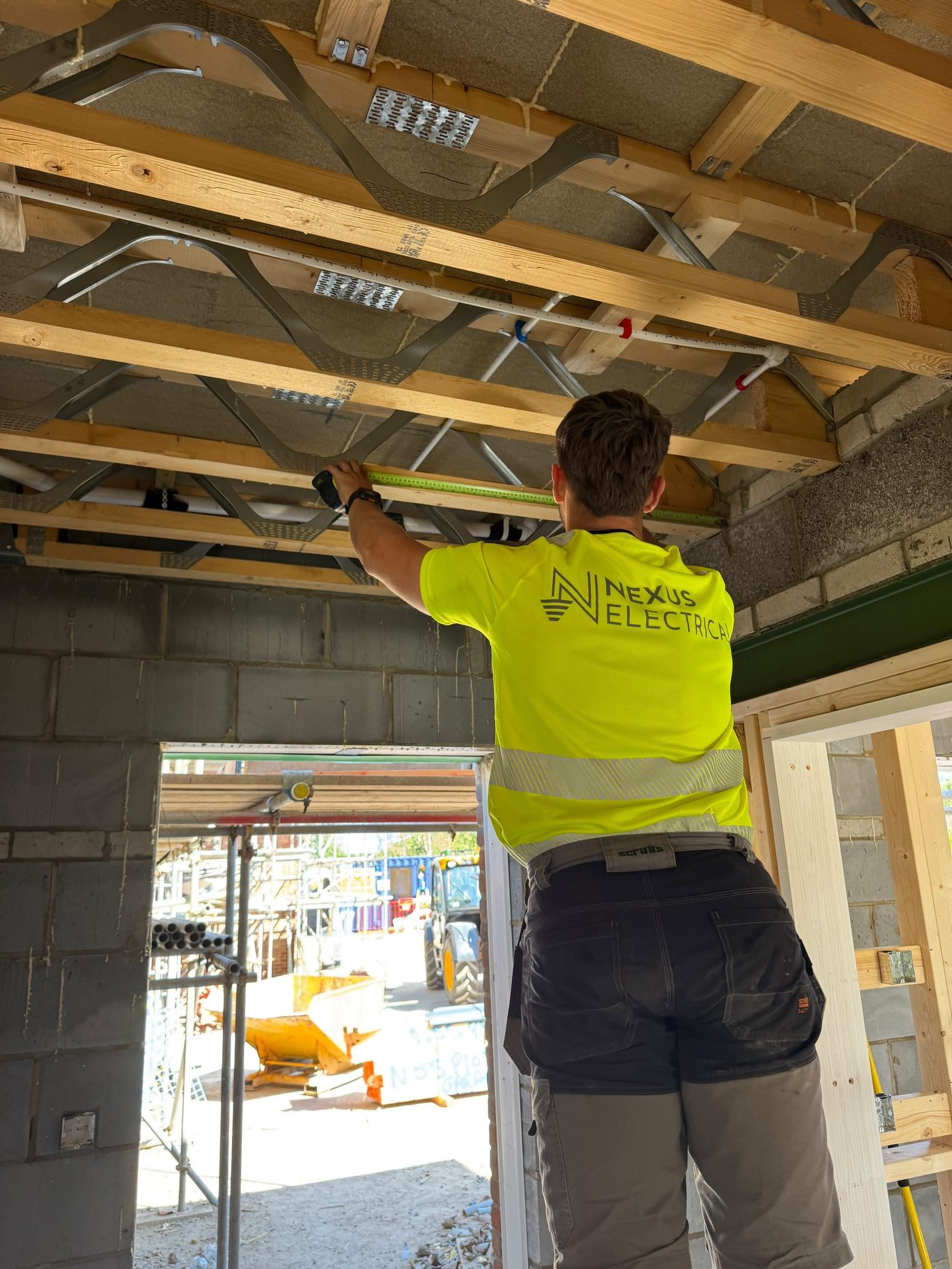 Tom from Nexus Electrical measuring up for cable runs in the ceiling joists