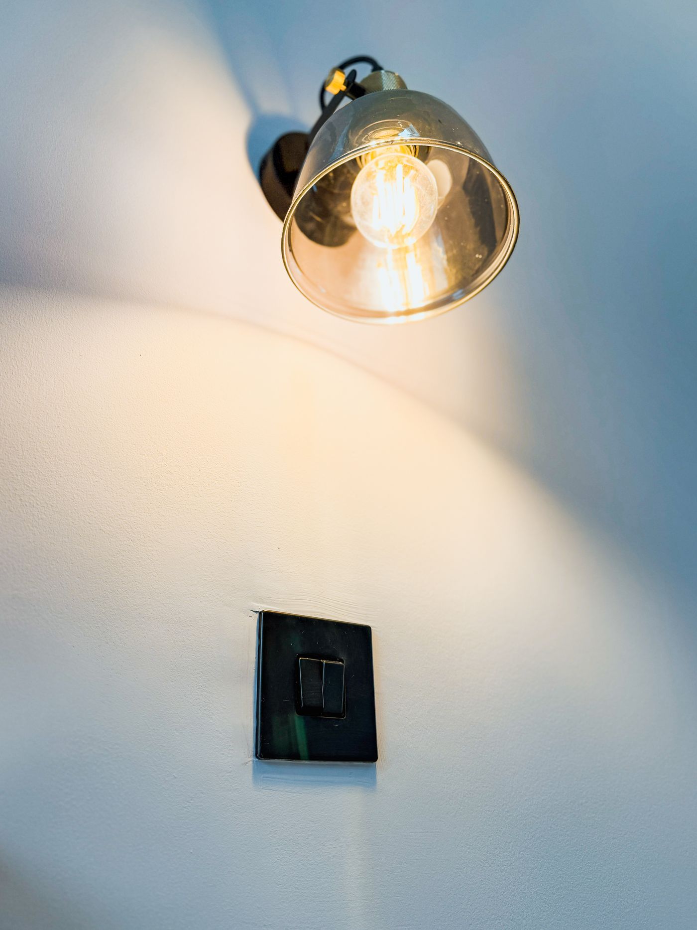 Brass wall light with a glass shade